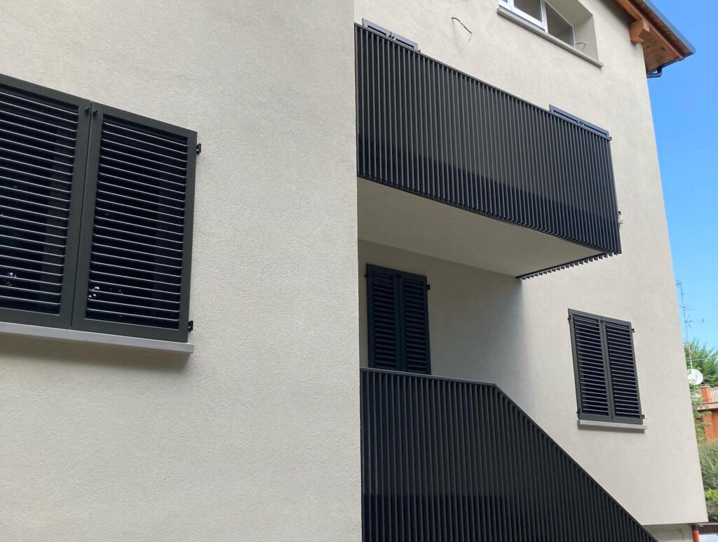 Parapetto balcone in ferro, con elementi verticali, minimali e moderni, di colore antracite scuro.