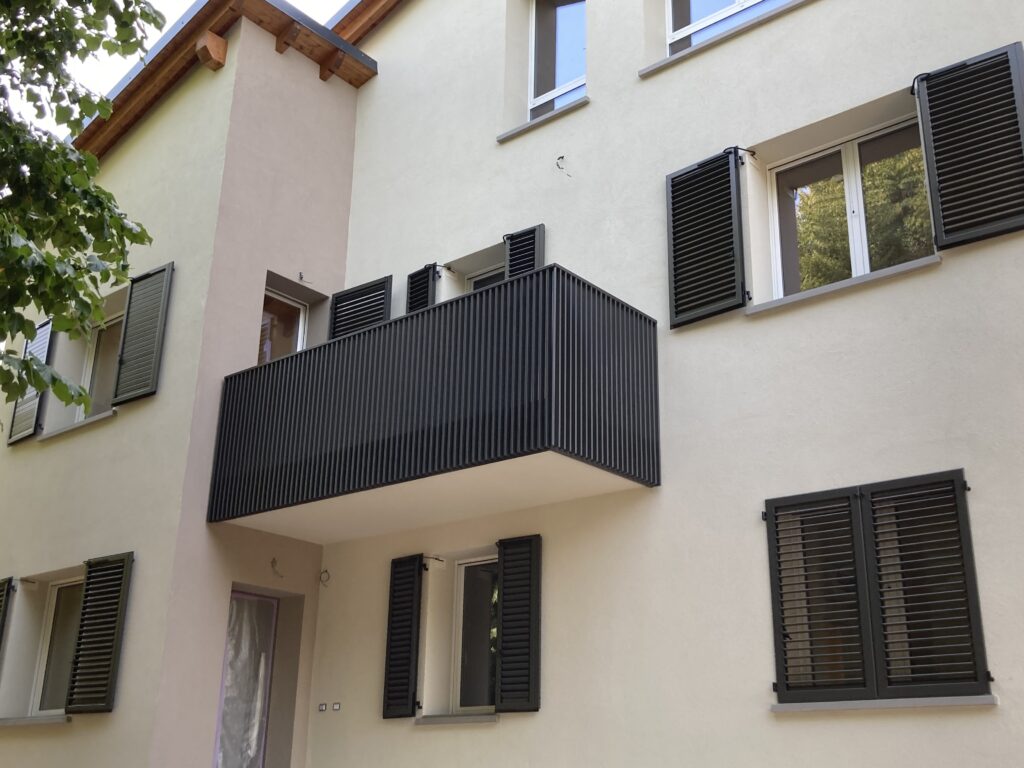 Parapetto balcone in ferro, con elementi verticali, minimali e moderni, di colore antracite scuro.